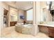 Luxurious bathroom with a standalone tub, granite counters, and ample natural light at 27632 N 68Th Pl, Scottsdale, AZ 85266