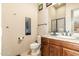 Bathroom with a dark wood cabinet, decorative mirror, a toilet, and a walk in shower at 27632 N 68Th Pl, Scottsdale, AZ 85266