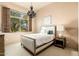 Bedroom with shuttered window with chandelier and a plush bed with side table at 27632 N 68Th Pl, Scottsdale, AZ 85266