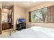 Bedroom showcasing window with shutters, a dresser, TV, and ensuite bath with a window view at 27632 N 68Th Pl, Scottsdale, AZ 85266