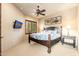 Comfortable bedroom featuring a ceiling fan, TV, and window with wood shutters at 27632 N 68Th Pl, Scottsdale, AZ 85266