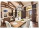 Bright dining room with wood floors, exposed beams, and views of the outdoor space at 27632 N 68Th Pl, Scottsdale, AZ 85266