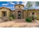 Charming home with a stone tower entrance, wrought iron gate, and lush landscaping at 27632 N 68Th Pl, Scottsdale, AZ 85266