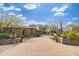 Grand desert home featuring a brick driveway, mature landscaping, and stone accents at the entrance at 27632 N 68Th Pl, Scottsdale, AZ 85266