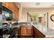 Kitchen with granite counters, a black microwave, and wooden cabinets at 27632 N 68Th Pl, Scottsdale, AZ 85266