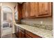 Kitchen counter with wood cabinets, granite countertop, microwave, and dark wood floor at 27632 N 68Th Pl, Scottsdale, AZ 85266