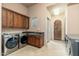 Spacious laundry room with modern washer and dryer units, granite countertop, and access to the backyard at 27632 N 68Th Pl, Scottsdale, AZ 85266