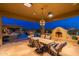 Spacious covered patio with outdoor dining, fireplace, TV, and views of the pool and putting green at 27632 N 68Th Pl, Scottsdale, AZ 85266