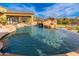 Beautiful pool area with a rock waterfall, patio, and outdoor entertaining area at 27632 N 68Th Pl, Scottsdale, AZ 85266