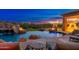 Resort-style pool with rock waterfall, water slide, and sun loungers, set against a twilight sky at 27632 N 68Th Pl, Scottsdale, AZ 85266