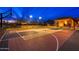 Lit multi-purpose sports court featuring basketball hoops, tennis net, and an outdoor entertainment space at 27632 N 68Th Pl, Scottsdale, AZ 85266