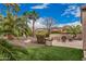 A well-manicured backyard featuring artificial grass, a seating area, and desert landscaping at 27792 N 129Th Ln, Peoria, AZ 85383