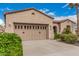 Home featuring a neutral palette, two-car garage with decorative windows, and desert landscaping at 27792 N 129Th Ln, Peoria, AZ 85383