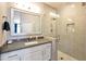 Bathroom with a tiled glass-enclosed shower, sleek countertop, and elegant mirror at 2992 N Miller Rd # A202, Scottsdale, AZ 85251