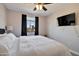 Bedroom with ceiling fan and large window with black curtains for natural light and a mounted television at 2992 N Miller Rd # A202, Scottsdale, AZ 85251