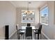 Bright dining room featuring modern table and chairs, chandelier, and a large window with neighborhood views at 2992 N Miller Rd # A202, Scottsdale, AZ 85251