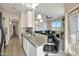 Bright, open kitchen with pendant lighting, grey countertops, stainless sink, and views of the living room at 2992 N Miller Rd # A202, Scottsdale, AZ 85251