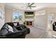 Comfortable living room featuring a fireplace, ceiling fan, and large windows that fill the space with natural light at 2992 N Miller Rd # A202, Scottsdale, AZ 85251