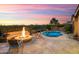 Twilight view of a backyard featuring a fire pit, pool, desert landscaping and mountain views at 30110 N 129Th Gln, Peoria, AZ 85383