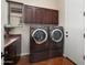 Well-lit laundry room with side-by-side washer and dryer units and built-in cabinets at 30110 N 129Th Gln, Peoria, AZ 85383