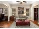 Bright living room with a gray sofa, leather ottoman, and large wall art at 30110 N 129Th Gln, Peoria, AZ 85383