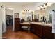 Bathroom vanity with double sinks and a large mirror, adjacent to a walk-in closet at 30110 N 129Th Gln, Peoria, AZ 85383