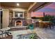 Covered patio featuring a fireplace, grill, bar and seating with a captivating sunset backdrop at 30110 N 129Th Gln, Peoria, AZ 85383