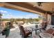 Covered patio featuring lounge seating, a fire pit, and a clear view of the sparkling pool at 30110 N 129Th Gln, Peoria, AZ 85383