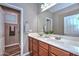 Bright bathroom featuring double sinks, wood cabinets and a large framed mirror at 30550 N 125Th Dr, Peoria, AZ 85383