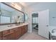 Bathroom with double vanity, framed mirror, and access to the main bedroom at 30550 N 125Th Dr, Peoria, AZ 85383