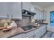 Bright kitchen with gray cabinets, granite countertops, and a modern electric cooktop stove at 30550 N 125Th Dr, Peoria, AZ 85383