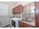 Functional laundry room with washer, dryer, sink, and storage cabinets at 30550 N 125Th Dr, Peoria, AZ 85383