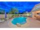 A backyard featuring a pool with tanning ledge, waterfall, a covered patio, and outdoor dining and lounging areas at 30550 N 125Th Dr, Peoria, AZ 85383