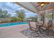 Inviting covered patio with a dining set offers a view of the sparkling pool and lush landscaping at 30550 N 125Th Dr, Peoria, AZ 85383