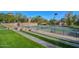 Well-maintained tennis court framed by lush green lawns and landscaped planters, perfect for active recreation at 30550 N 125Th Dr, Peoria, AZ 85383