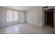 Neutral living room featuring tile flooring, a large window, and access to other rooms at 3646 N 67Th Ave # 12, Phoenix, AZ 85033
