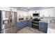 Bright kitchen featuring white and blue cabinets and stainless steel refrigerator at 4338 E Towne Ln, Gilbert, AZ 85234