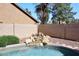 A refreshing pool area with a serene rock waterfall feature, landscaping, and a block fence at 4338 E Towne Ln, Gilbert, AZ 85234