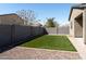 Gravel and grass backyard featuring a concrete block wall, landscaping and blue skies at 625 W Panola Dr, San Tan Valley, AZ 85140