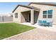 Gravel and grass backyard featuring a covered patio with blue table and chairs and block wall at 625 W Panola Dr, San Tan Valley, AZ 85140