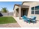 Gravel and grass backyard featuring a covered patio with blue table and chairs and block wall at 625 W Panola Dr, San Tan Valley, AZ 85140