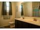 Bright bathroom featuring a double sink vanity with bronze faucets, a decorative mirror and modern fixtures at 625 W Panola Dr, San Tan Valley, AZ 85140