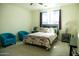 Cozy bedroom featuring a patterned bedspread, comfortable blue chairs, and large bright window at 625 W Panola Dr, San Tan Valley, AZ 85140