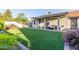 This backyard includes a covered patio, artificial grass, and lush, mature landscaping at 756 E Appaloosa Rd, Gilbert, AZ 85296