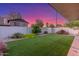 The backyard features artificial grass, colorful landscaping and a block wall for privacy at 756 E Appaloosa Rd, Gilbert, AZ 85296