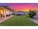 A beautiful backyard features artificial grass, a covered patio, and tasteful landscaping at 756 E Appaloosa Rd, Gilbert, AZ 85296