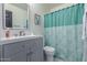 Charming bathroom features a modern vanity, a decorative mirror, and a shower with a turquoise curtain at 756 E Appaloosa Rd, Gilbert, AZ 85296