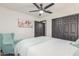 This bedroom features a ceiling fan, closet with sliding doors, artwork, and a comfortable sitting chair at 756 E Appaloosa Rd, Gilbert, AZ 85296