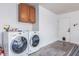 Functional laundry room with washer, dryer, and overhead storage cabinets at 756 E Appaloosa Rd, Gilbert, AZ 85296