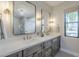 Bright bathroom with dual sinks, modern lighting, and stone finished cabinets at 8100 E Camelback Rd # 143, Scottsdale, AZ 85251